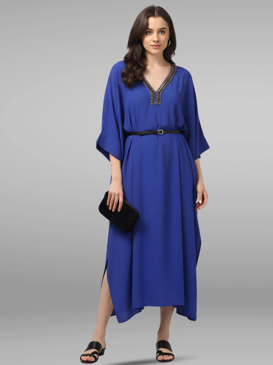 Woman wearing a blue dress with a black belt on a gray background