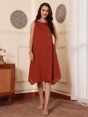 Woman wearing a rust-colored cotton linen dress in an elegant room.
