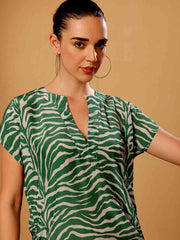 Stylized campaign shot of Green animal print beach coverup in a scenic resort setting