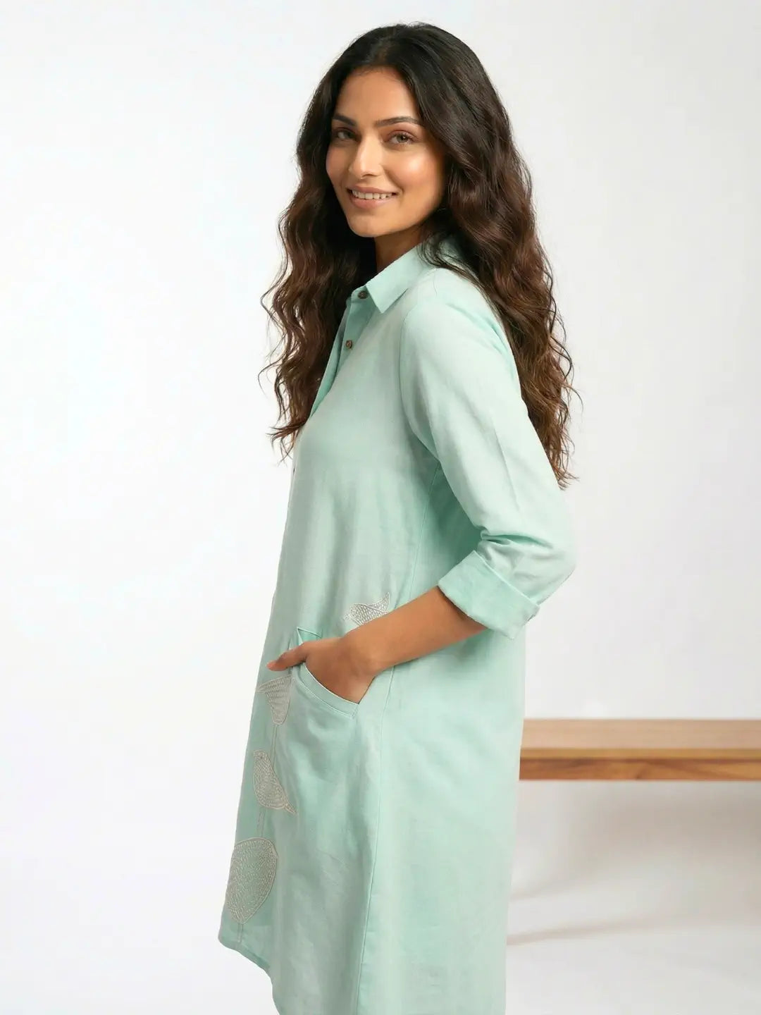 Side profile of a women wearing a cotton Linen Mint color vacation Shirt dress with Birds embroidery