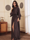 Left pose of a Woman wearing a brown co-ord set with crop top and Skirt with Slit in a room with decorative elements.