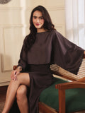 Woman sitting on a bench wearing a brown co-ord set with crop top and Skirt with Slit in a room with decorative elements.