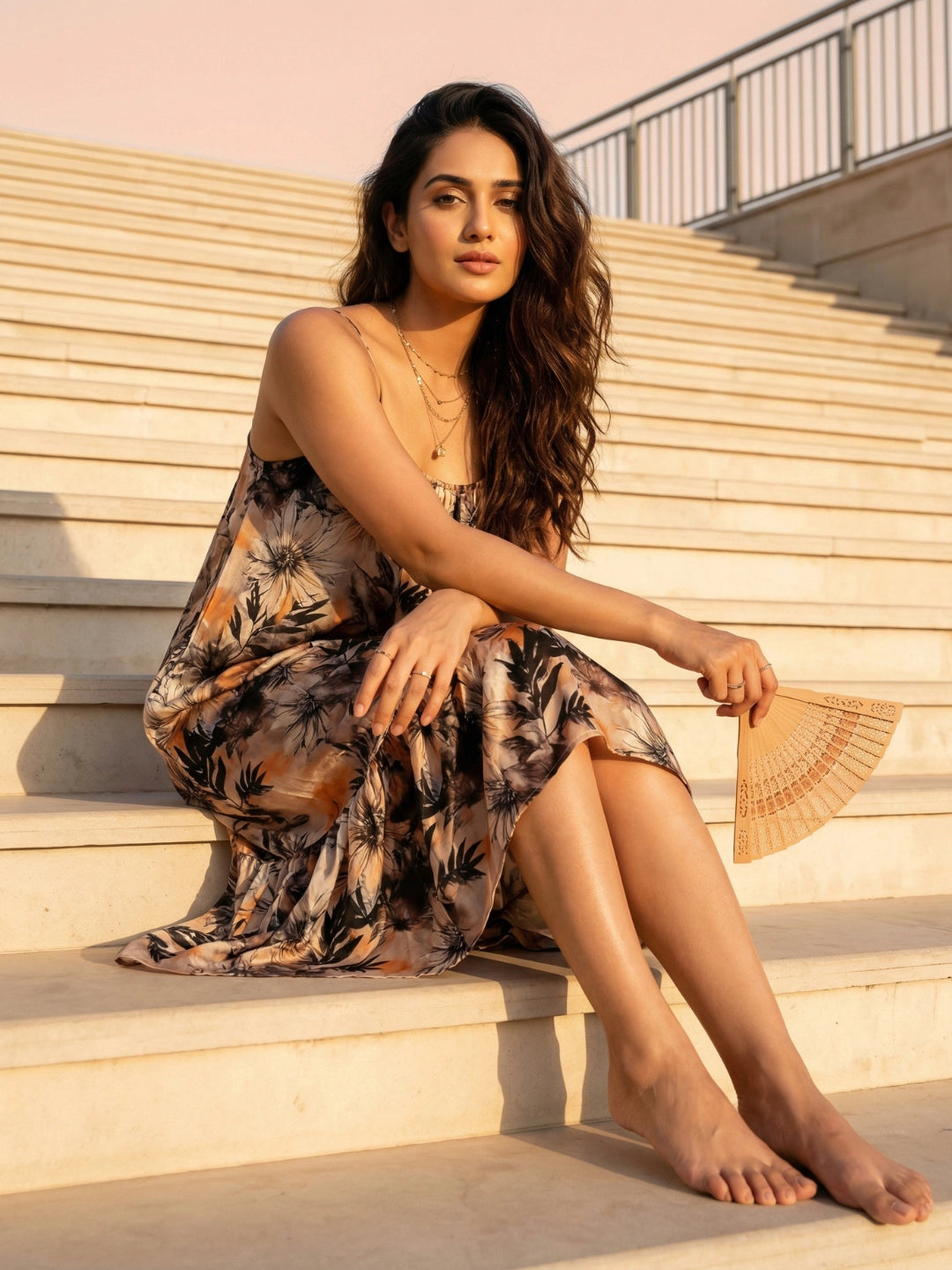 Woman in a floral dress sitting on steps outdoors