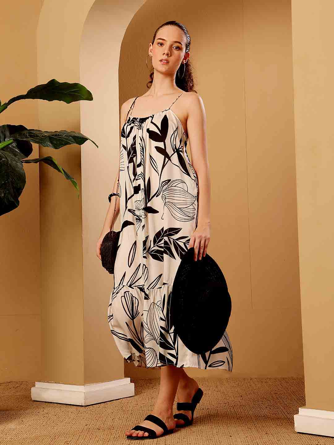 Stylized campaign shot of tropical printed resort maxi dress in a scenic resort setting
