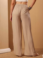 Back view of Beige resort flared pants highlighting structure and styling from the rear

