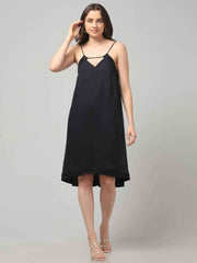 Women wearing a black resort wear cocktail dress with noodle strap and black embellishment on neckline