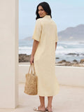 Back profile of a Woman in a cotton linen blend yellow shirt dress with embroidery holding a straw bag by a beach.