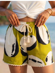 Closeup shot of a women wearing 100% viscose printed shorts with drawcord and tassel on a beach