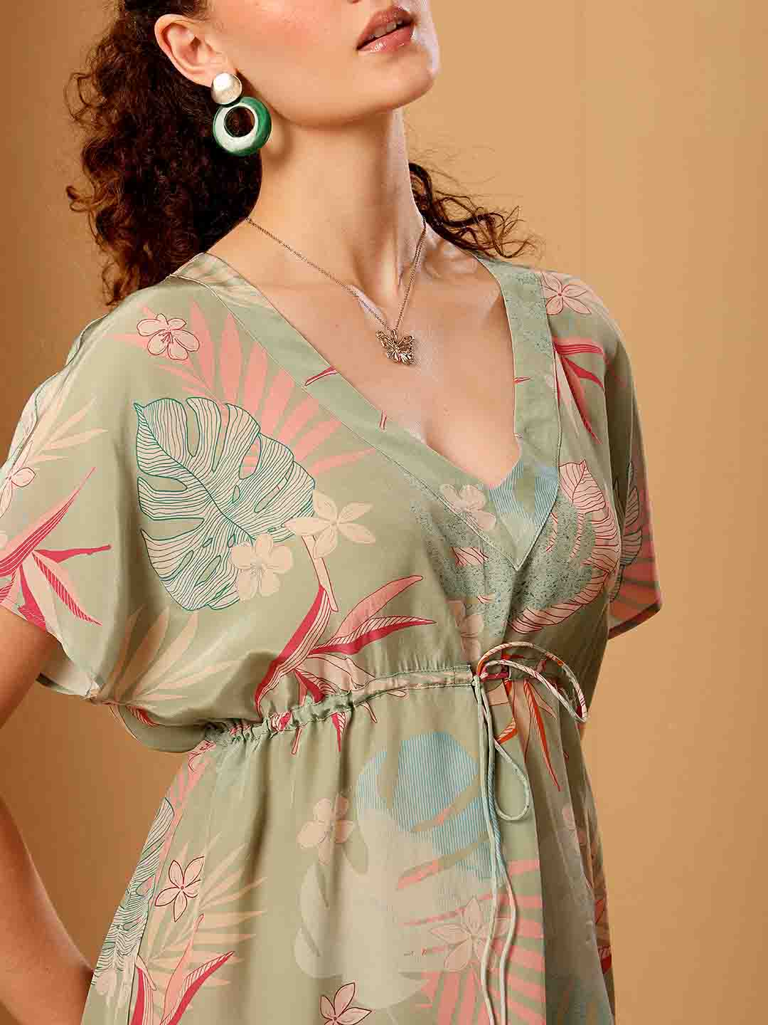 Green tropical printed beach cover up showing detailed neckline, print detail and fall of the garment