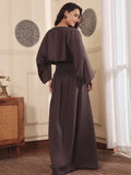 Back pose of a Woman wearing a brown co-ord set with crop top and Skirt with Slit in a room with decorative elements.