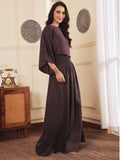 Right pose of a Woman wearing a brown co-ord set with crop top and Skirt with Slit in a room with decorative elements.