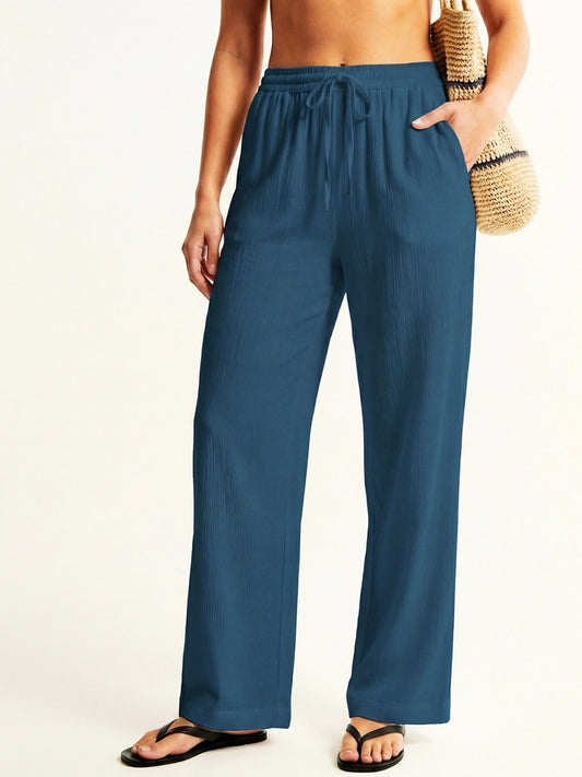 Person wearing teal resort pants on a white background