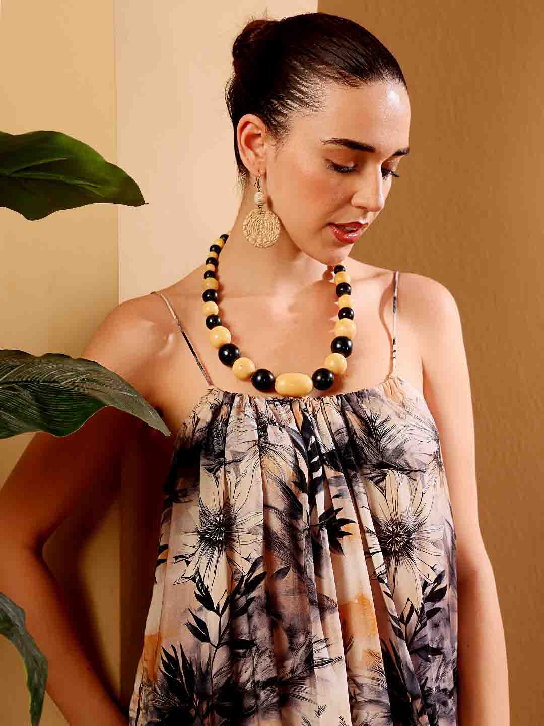 Front close-up of tropical floral resort dress showing intricate fabric and neckline detail
