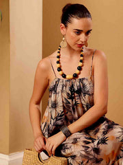 Stylized campaign shot of tropical floral resort dress in a scenic resort setting
